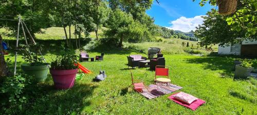 a group of chairs sitting in the grass in a yard at Hôtel et Appart'Hôtel Restaurant L'Adray in Longefoy