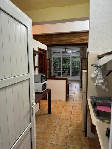een keuken met een deur naar een keuken met een fornuis bij Les Mangroves in Mahébourg
