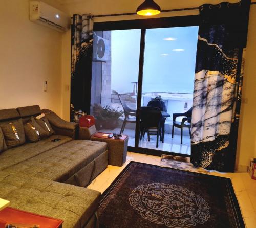 a living room with a couch and a large window at السخنة هيلز مدينة الجلالة Sokhna Hills Al Galala City Family only in Ain Sokhna