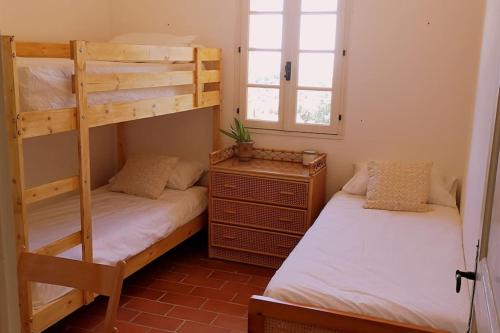 une chambre avec deux lits superposés et une fenêtre dans l'établissement Maison provençale vue mer Croix Valmer 