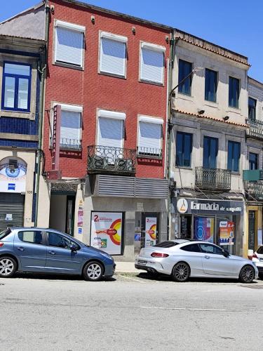 two cars parked on a street in front of a building at HOSPEDARIA LONDRES in Porto