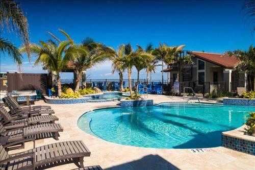 a swimming pool with chairs and palm trees and the ocean at The Rod and Reel Resort Suite 2 in Anna Maria
