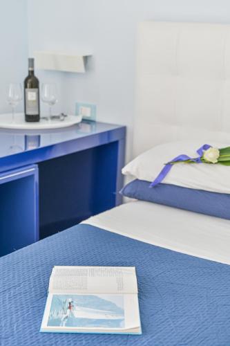 a bottle of wine sitting on top of a bed at LINUS by BREATHE LIGURIA in La Spezia