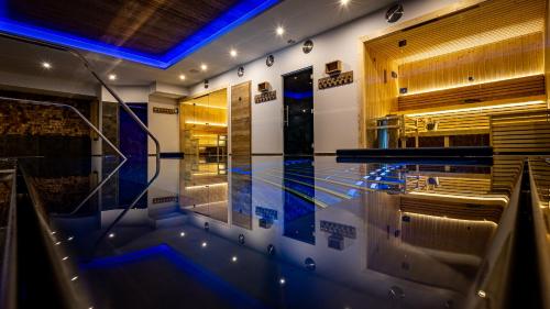 a swimming pool in a building with blue lights at Hôtel SPA du Lac de Madine - Maison DRAPIER in Heudicourt-sous-les-Côtes