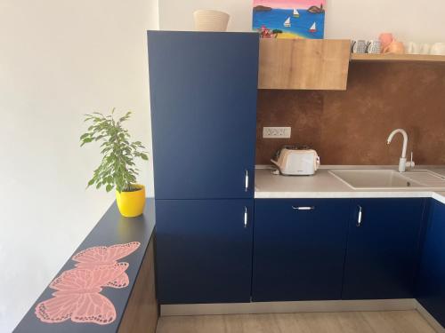 a kitchen with blue cabinets and a sink at Summer time in Pisak