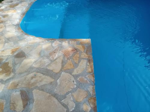 a swimming pool with a stone floor and blue water at Bazen in Sarajevo