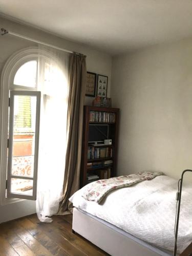 une chambre avec un lit et une fenêtre dans l'établissement grand studio en plein centre de Trouville, à Trouville-sur-Mer