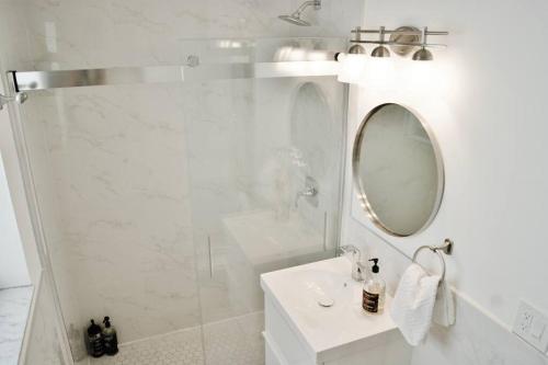 une salle de bain blanche avec un lavabo et un miroir dans l'établissement Tranquil 2 bed 1 bath at Beach, Glimpse of the Ocean, à Miami Beach