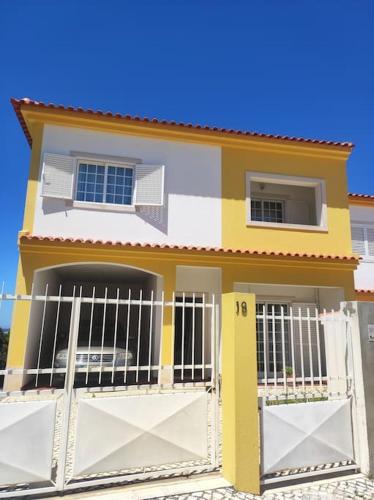 a house with a gate in front of it at Casa das Rosas - Moradia com jardim e churrasco, Charneca da Cotovia in Sesimbra