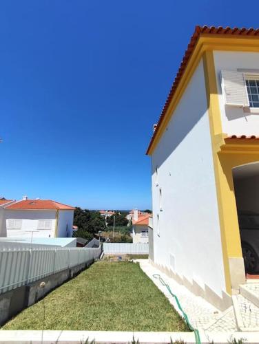 a side view of a house with a yard at Casa das Rosas - Moradia com jardim e churrasco, Charneca da Cotovia in Sesimbra