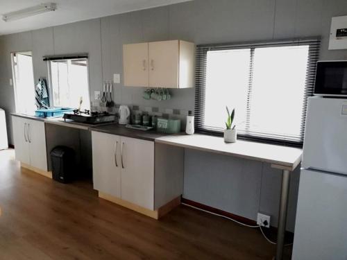 a kitchen with white cabinets and a white refrigerator at Wellust Cottage at Ngweni Private Game Farm in Hluhluwe