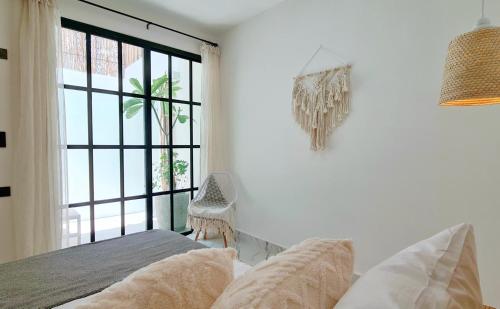 a bedroom with a bed and a large window at Casa Ecos d' Alma in Isla Mujeres