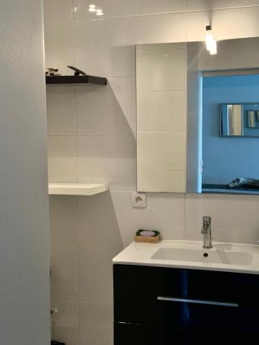 une cuisine blanche avec un évier et une fenêtre bleue dans l'établissement Cute studio next to beach, à Saint-Laurent-du-Var