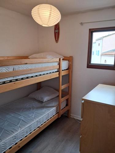 deux lits superposés dans une chambre avec fenêtre dans l'établissement Appartement vue mer sur marina, à Saint-Cyprien