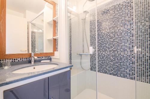 une salle de bain avec un lavabo et une douche en verre dans l'établissement Résidence le Hameau de Cap Esterel - maeva Home - Appartement 2 pièces 4 personnes - Prestige MAE-6441, à Saint-Raphaël