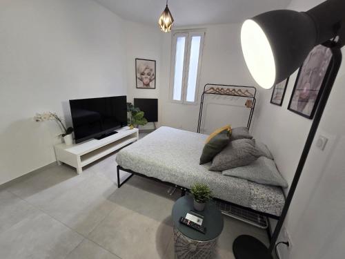 une chambre blanche avec un lit et une télévision dans l'établissement GregBnb - Studio 22m2 - Climatisé -10min Gare - 1, à Toulon