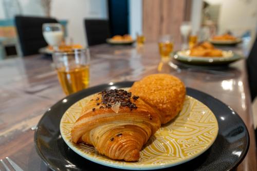 a plate with a croissant and bread on a table at Maison Cosy in Saint-Denis