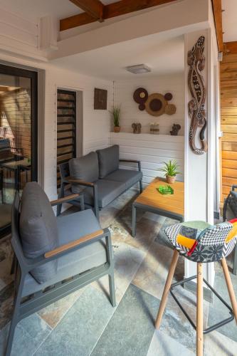 a porch with chairs and a couch and a table at Maison Cosy in Saint-Denis
