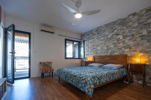 a bedroom with a bed and a brick wall at Maison Cosy in Saint-Denis