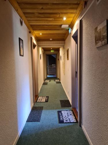 an empty hallway with a wooden ceiling at Hôtel et Appart'Hôtel Restaurant L'Adray in Longefoy