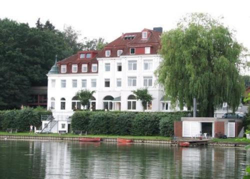 a large white house sitting on the side of a lake at Hotel Seeschloss am Kellersee in Eutin