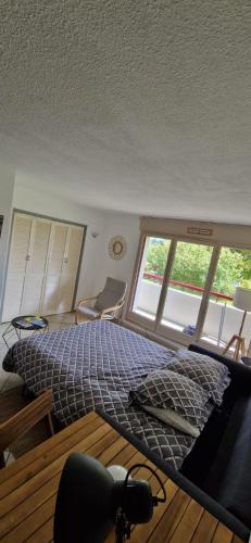 Un dormitorio con una cama grande y dos ventanas. en Appartement Bidart Plage, en Bidart