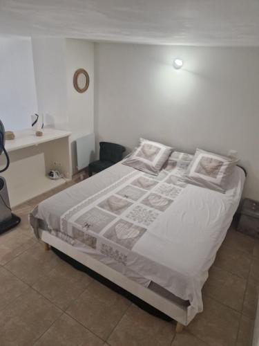 une chambre avec un lit avec des draps blancs et des oreillers dans l'établissement Appartement 42m2, à Hyères