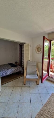 Un dormitorio con una cama y una silla en una habitación. en Appartement Bidart Plage, en Bidart