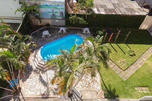 an overhead view of a swimming pool in a yard with palm trees at HANNA Praia Hotel - Florianópolis in Florianópolis