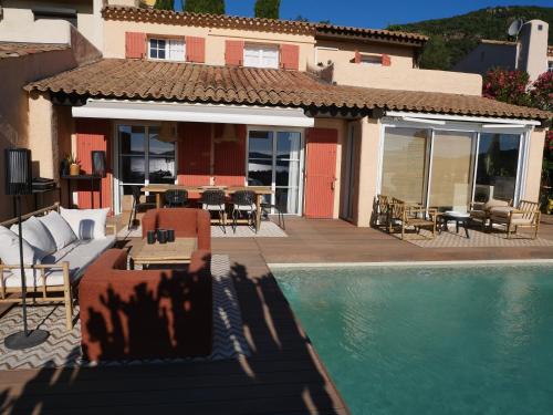 une maison avec une piscine devant une maison dans l'établissement Mas de charme 133m2 piscine chauffée vue mer panoramique, à Cavalaire-sur-Mer