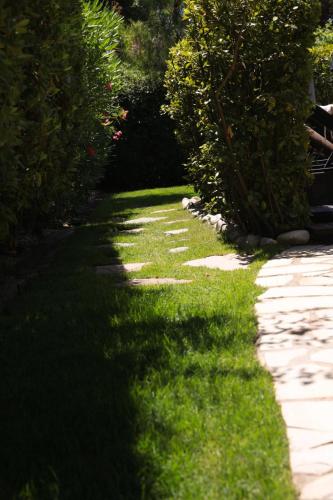 a garden with green grass and a pathway at Hebe la villa in Cogolin