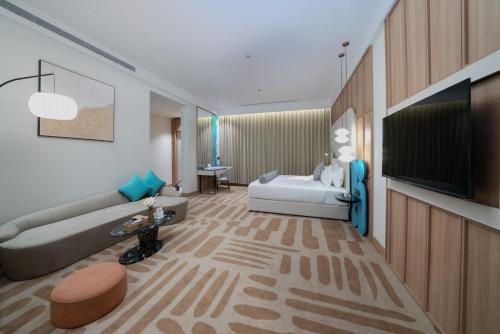 a living room with a couch and a tv at Sunway Tabuk Hotel in Tabuk