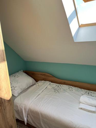 a small bedroom with a bed and a window at Wooden house Ante self check - in and check - out in Otočac