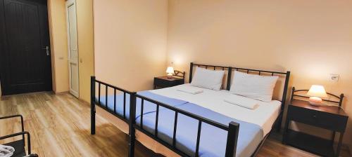 a bedroom with a bed with white sheets and pillows at Light Hotel in Tbilisi City