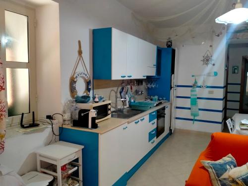 a kitchen with blue and white cabinets and a sink at Solemare in Gioiosa Marea