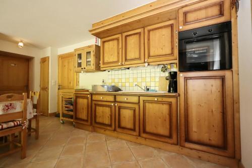 une cuisine avec des armoires en bois et un évier dans l'établissement Résidence Le Hameau Des Glaciers - Hameau des Glaciers D02 MAE-5834, aux Houches