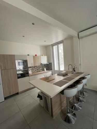 - une cuisine avec un comptoir et quelques tabourets dans l'établissement Appartement cosy, à Toulon