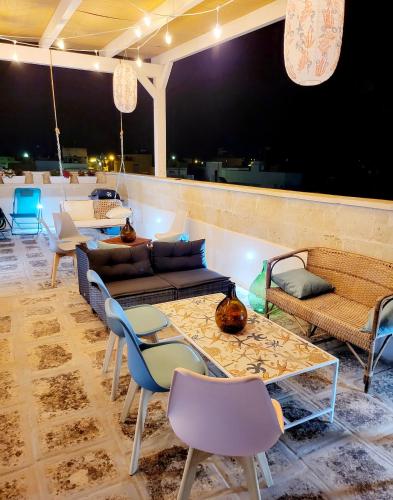 a living room with couches and tables and chairs at Aquamarina Rooms in Porto Cesareo