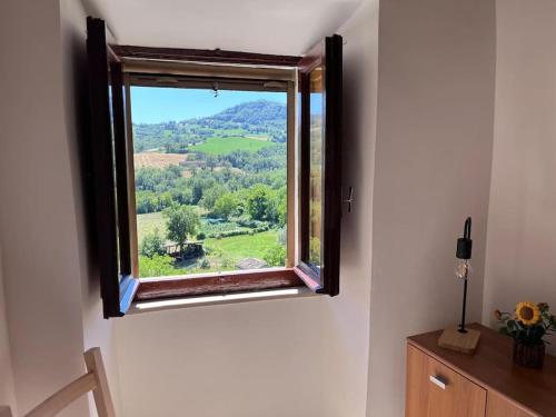 a window with a view of a green field at La Baita dei Sibillini in Ceretana
