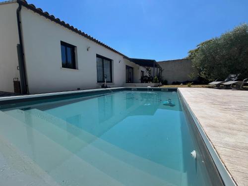 une piscine devant une maison dans l'établissement Villa Spacieuse avec Piscine, à Entraigues-sur-la-Sorgue