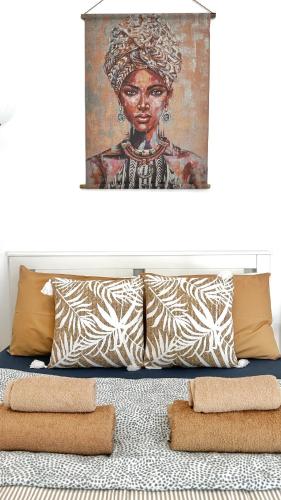a painting of a woman on a bed with pillows at PMP Adamia Apartments in Peyia