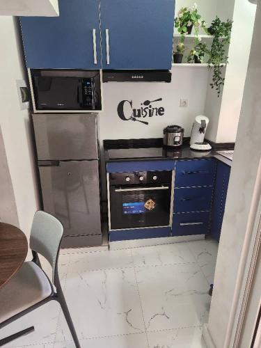 a small kitchen with blue cabinets and a stove at Over cloud 1 in Marcory