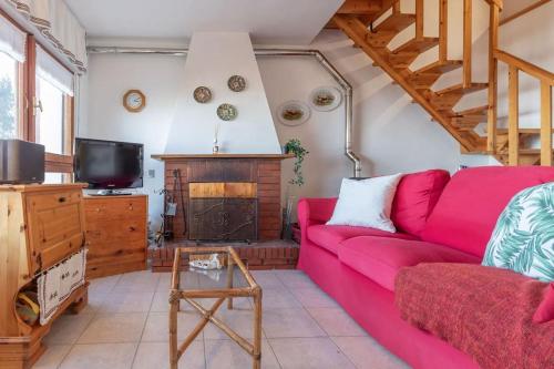 a living room with a red couch and a fireplace at Chalet Aria Sottile in Sassotetto