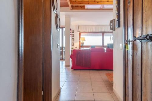 a hallway with a living room with a red couch at Chalet Aria Sottile in Sassotetto