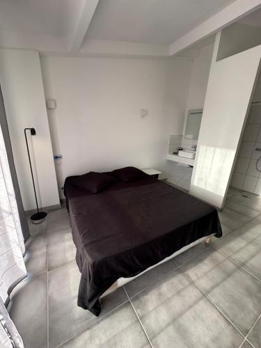 - une chambre blanche avec un lit noir dans l'établissement Experience intime, à Torreilles