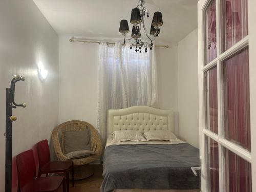 une chambre avec un lit, une chaise et une fenêtre dans l'établissement Nido, à Saint-Denis