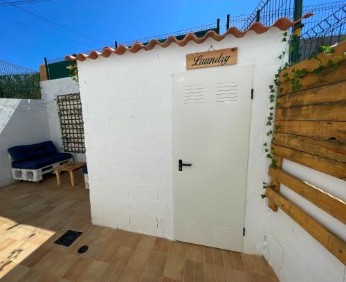 a white shed with a sign on top of it at Calo's Place in Fisterra