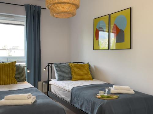 a room with two beds and a table with towels at URBAN APARTMENTS PREMIUM Baildona No 11 FREE GARAGE, Self CHECK-IN in Katowice