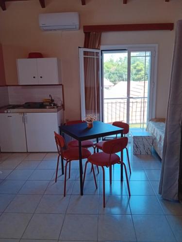 a kitchen with a table and chairs in a room at Valta's Room in Paleros