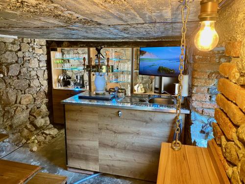 a kitchen with a counter with a sink and a tv at Privát Adriana in Kremnica